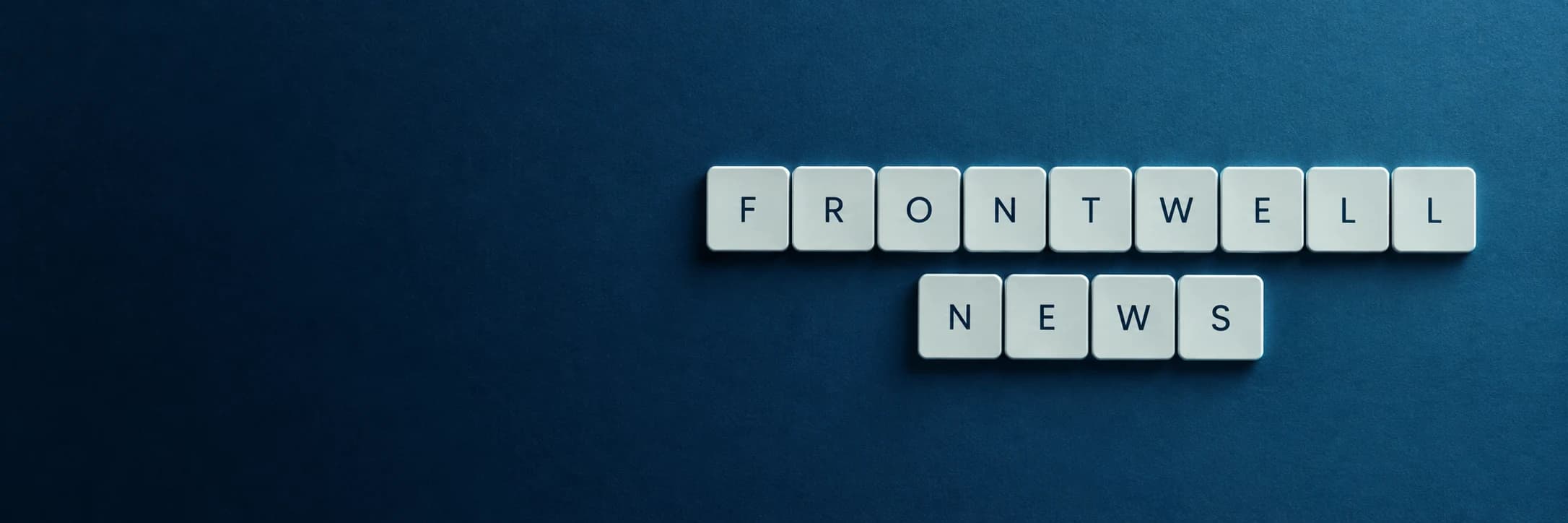 White keyboard keys spelling FrontWell News on a deep blue background