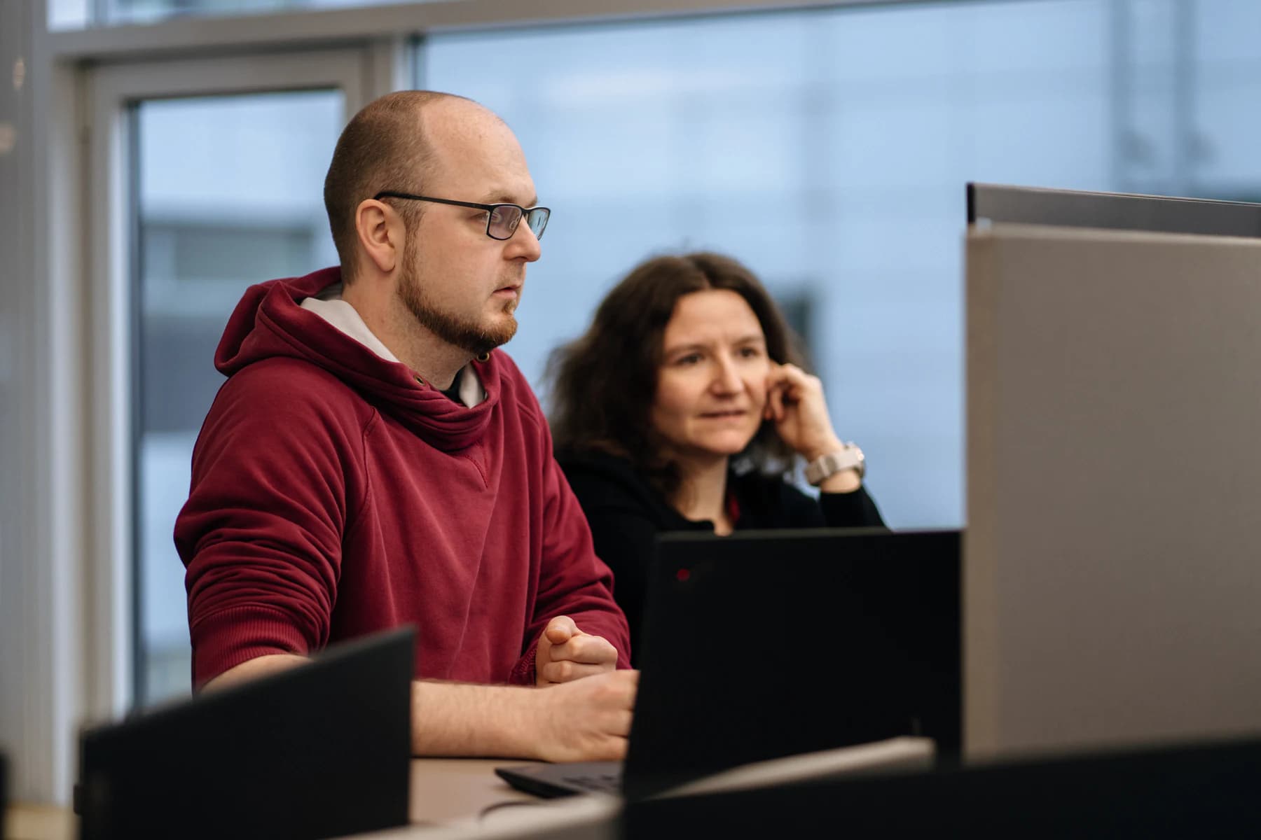 Two FrontWell colleagues focused on work at their monitors.